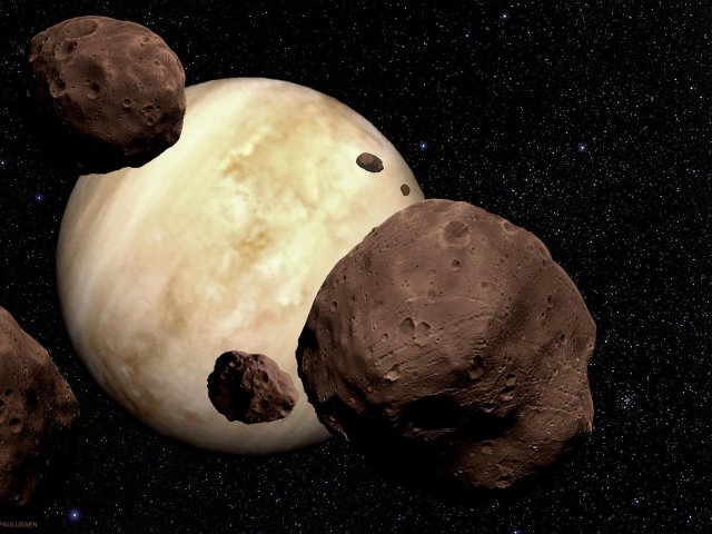 Ein Schwarm aus massigen Asteroiden driftet in Richtung der stets wolkenumhüllten Venus.